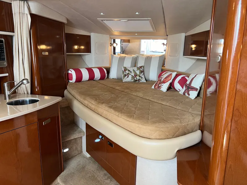 Slide: The Image of 2011 Sea Ray 330 Sundancer cabin with luxurious bedding and elegant wood finishes. - 22