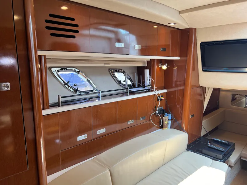 Slide: The Image of Interior of 2011 Sea Ray 330 Sundancer yacht with wood cabinetry and porthole windows. - 24