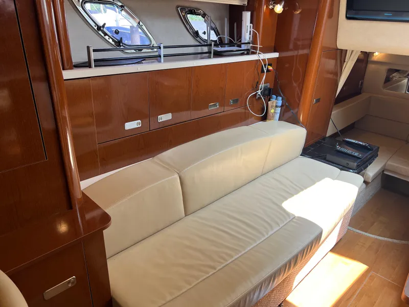 Slide: The Image of Interior of 2011 Sea Ray 330 Sundancer with beige sofa and wooden cabinetry. - 25