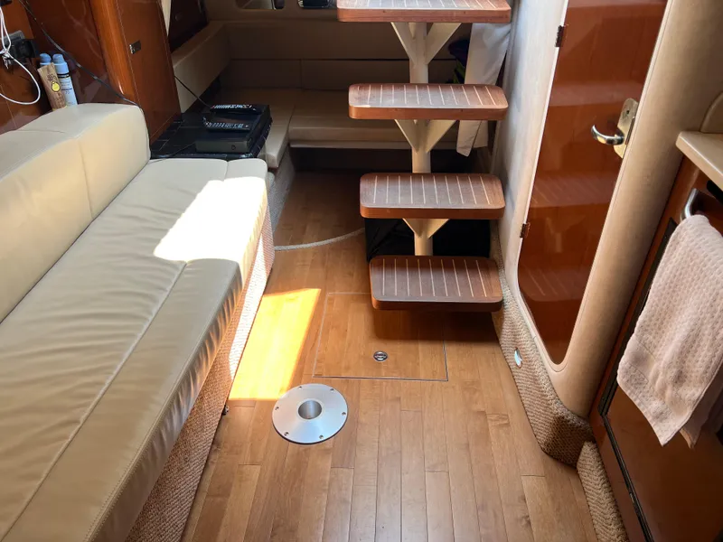 Slide: The Image of Interior of 2011 Sea Ray 330 Sundancer with wooden flooring and beige seating. - 26