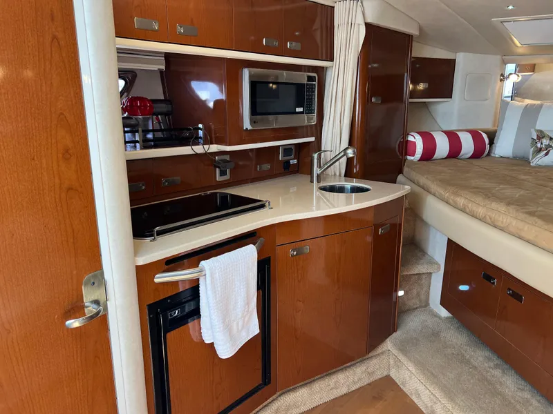 Slide: The Image of Interior of 2011 Sea Ray 330 Sundancer with kitchenette and cozy sleeping area. - 28