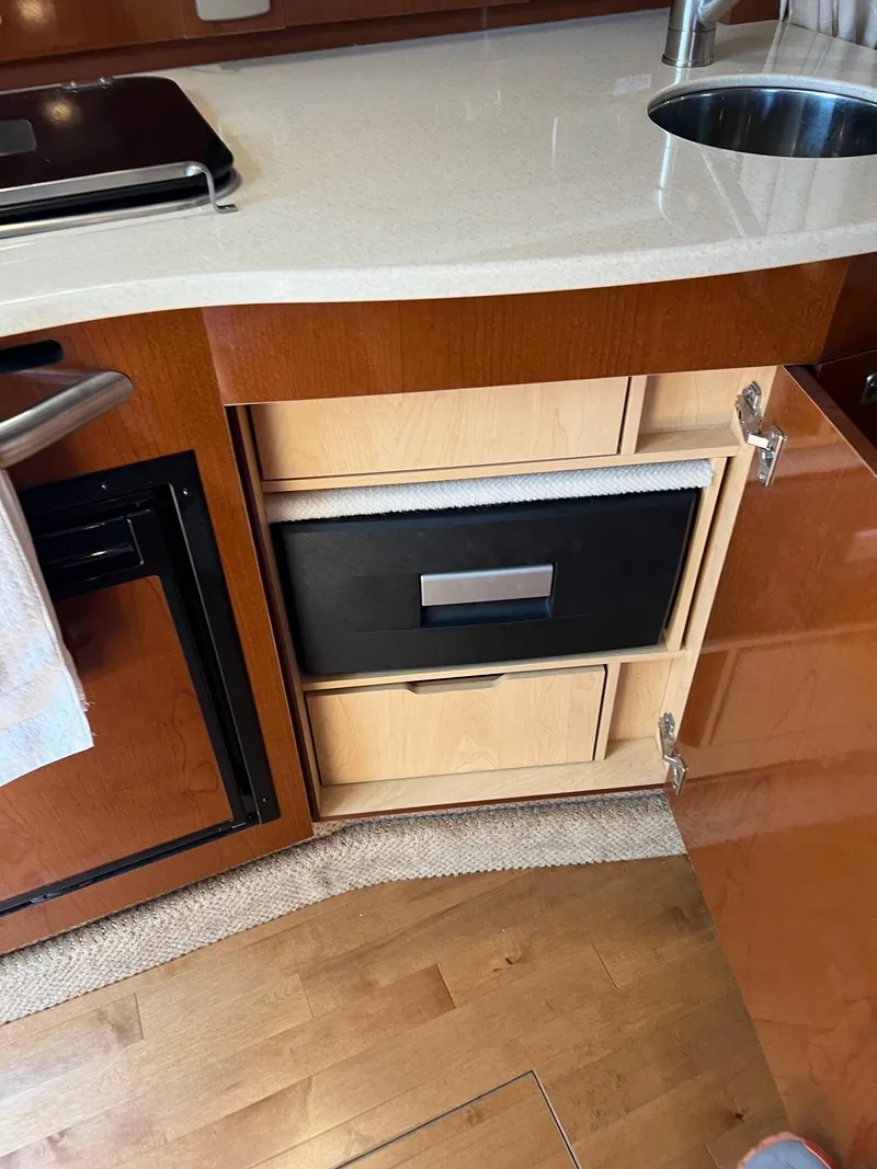 Slide: The Image of Interior of 2011 Sea Ray 330 Sundancer showing kitchen cabinetry and sink. - 32