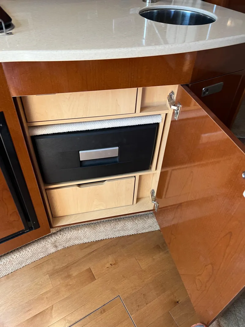 Slide: The Image of 2011 Sea Ray 330 Sundancer interior with open cabinet and sink. - 33