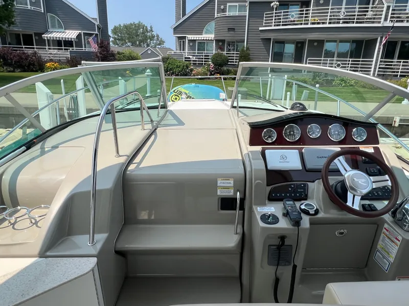 Slide: The Image of 2011 Sea Ray 330 Sundancer boat cockpit with modern controls and waterfront view. - 6