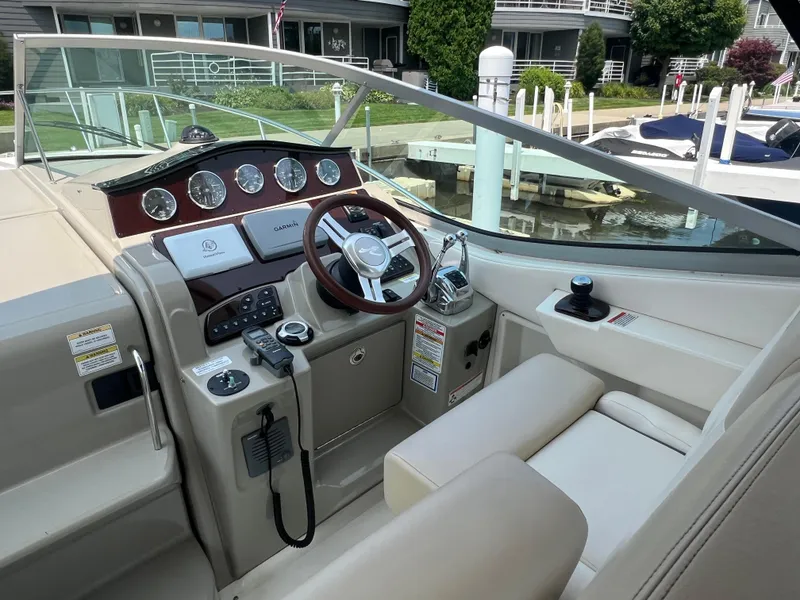 Slide: The Image of 2011 Sea Ray 330 Sundancer helm with steering wheel and control panel at marina. - 7