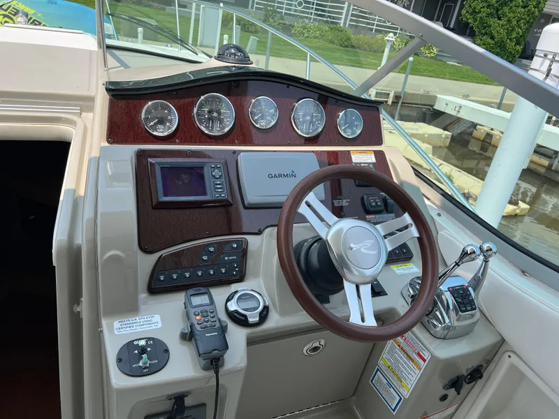 Slide: The Image of 2011 Sea Ray 330 Sundancer helm with Garmin navigation, gauges, and steering wheel. - 8