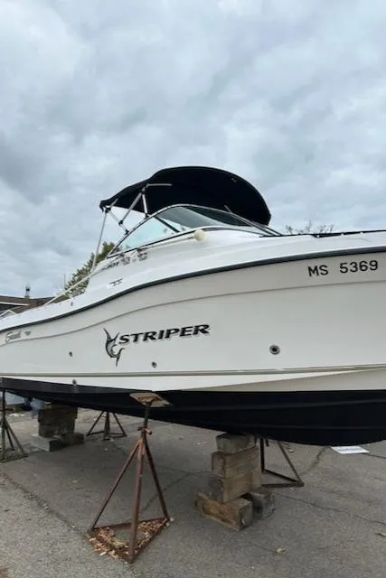 Slide: The Image of 2005 Seaswirl Striper 2301 Dual Console O/B boat on stands, cloudy sky background. - 10