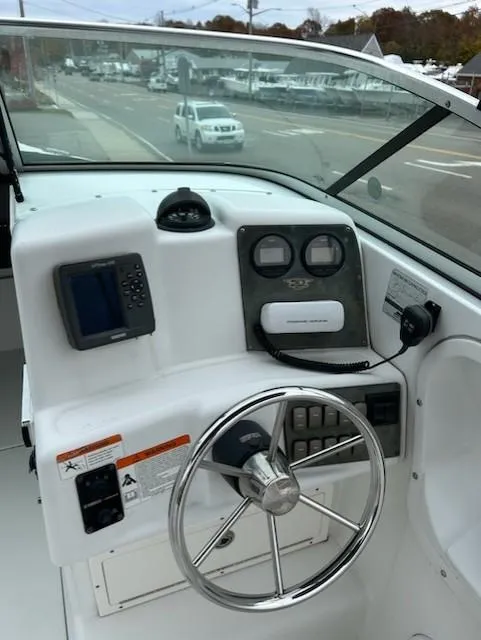 Slide: The Image of 2005 Seaswirl Striper 2301 Dual Console boat dashboard with steering wheel and controls. - 11