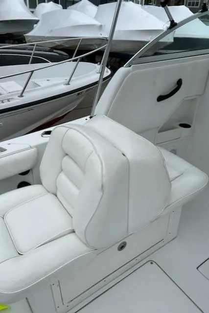 Slide: The Image of 2005 Seaswirl Striper 2301 Dual Console O/B boat with white seating, docked. - 13