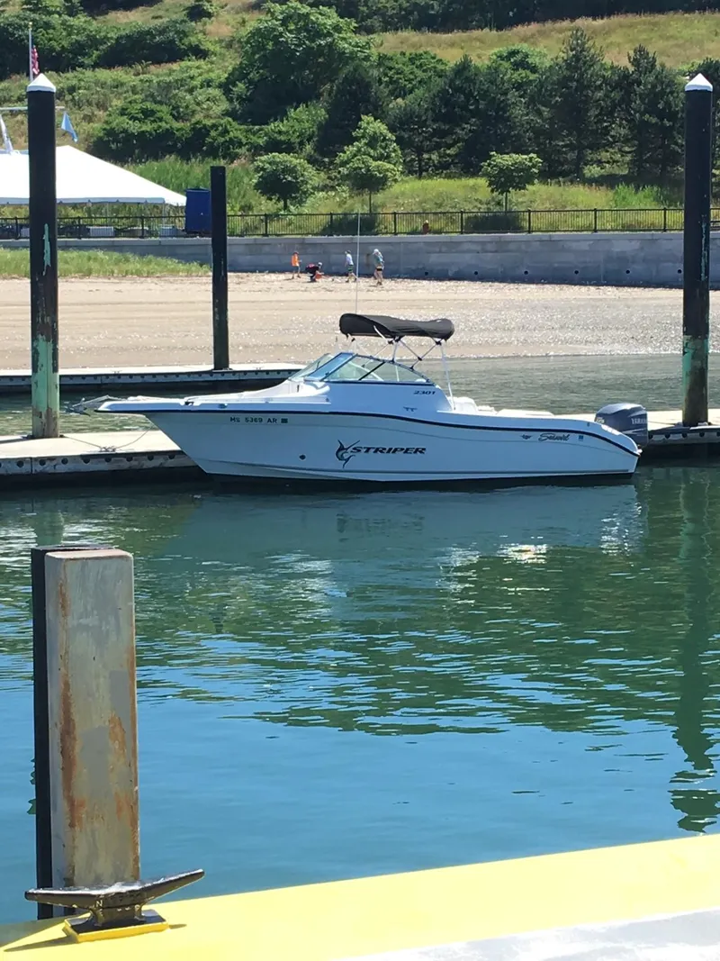 Slide: The Image of 2005 Seaswirl Striper 2301 Dual Console O/B boat docked in a sunny marina. - 15