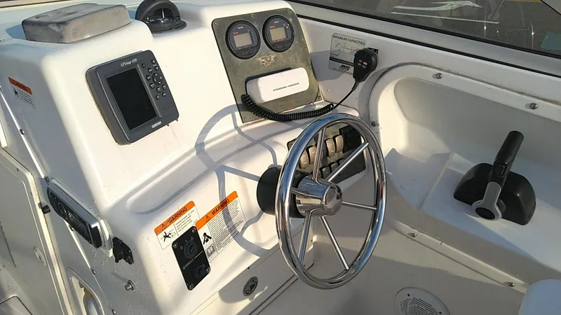 Slide: The Image of 2005 Seaswirl Striper 2301 Dual Console O/B boat dashboard with steering wheel and controls. - 5