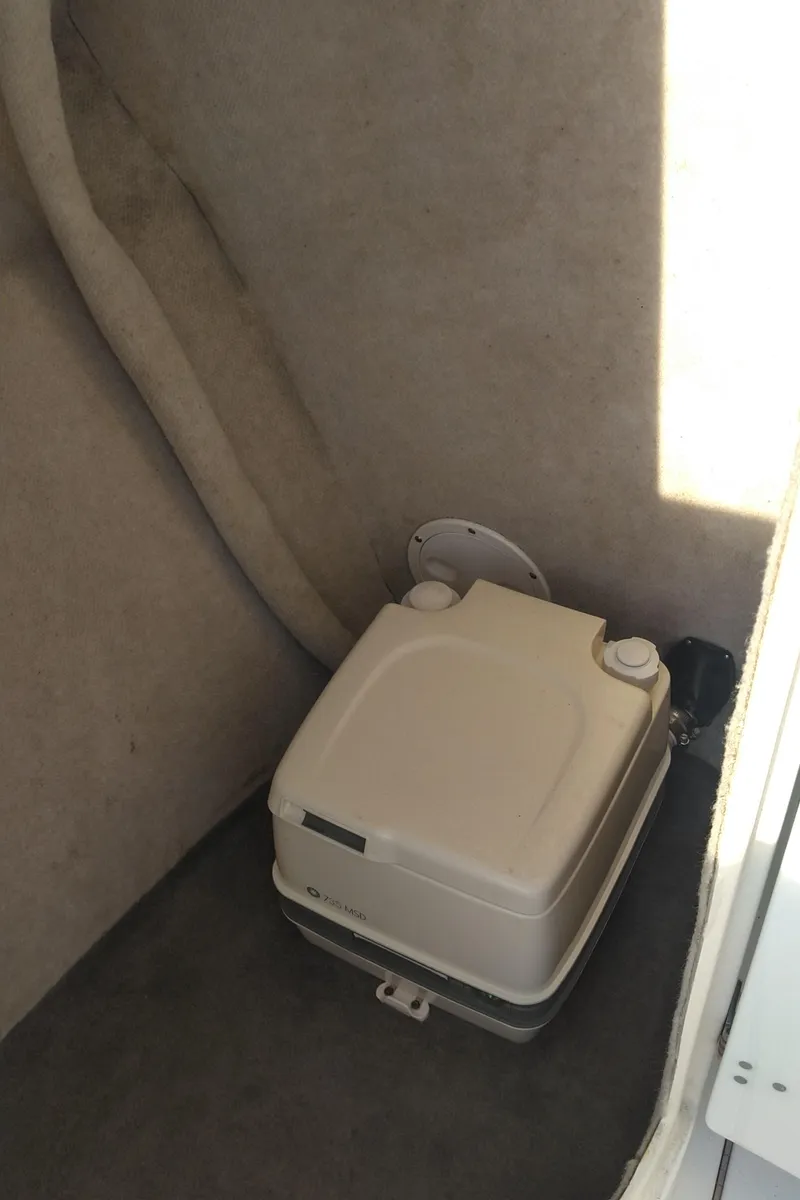 Slide: The Image of 2005 Seaswirl Striper 2301 Dual Console O/B interior with portable toilet. - 7