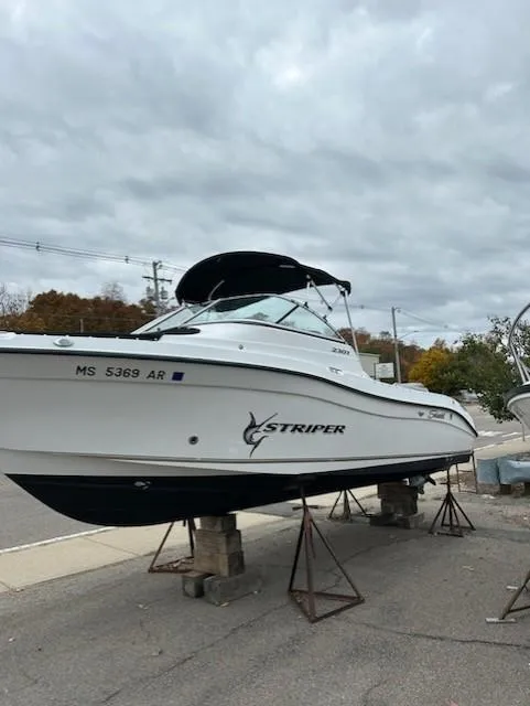 Slide: The Image of 2005 Seaswirl Striper 2301 Dual Console O/B boat on stands, cloudy sky background. - 9