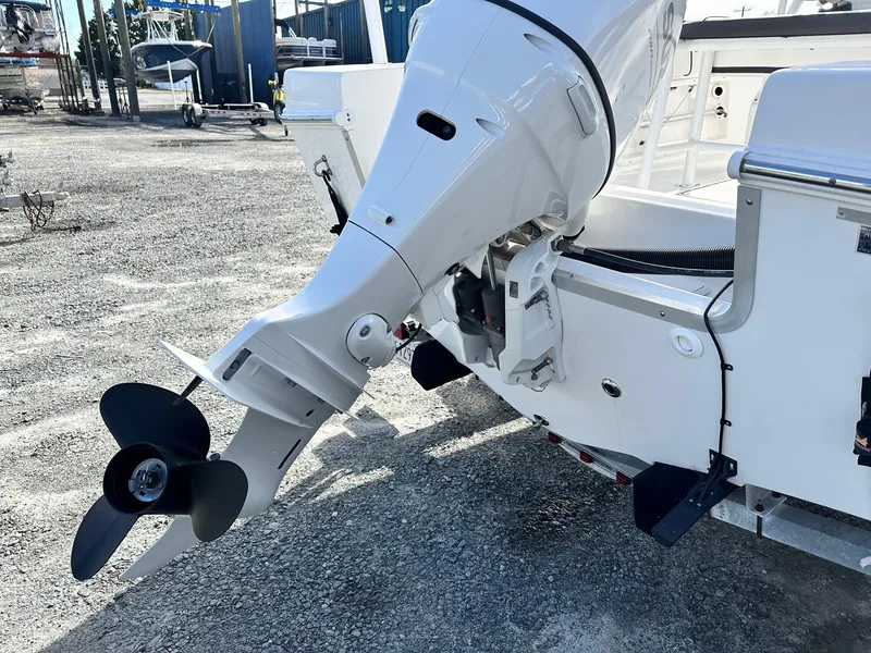 Slide: The Image of Clearwater 2000CC 2022 boat engine and propeller in a marina setting. - 14