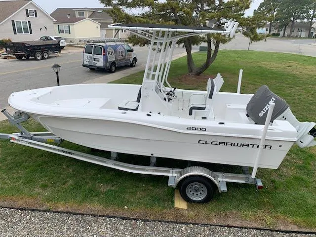 Slide: The Image of 2022 Clearwater 2000CC boat on trailer, parked on grass in residential area. - 3