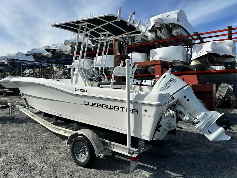 Slide: The Image of 2022 Clearwater 2000CC boat on trailer with Suzuki outboard motor, parked outdoors. - 4