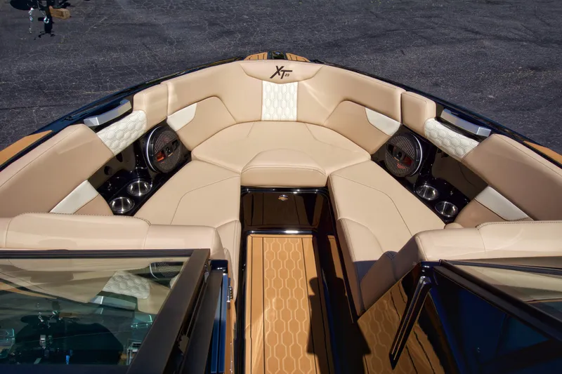 Slide: The Image of 2025 MasterCraft XT23 boat interior with beige seating and premium audio system. - 12