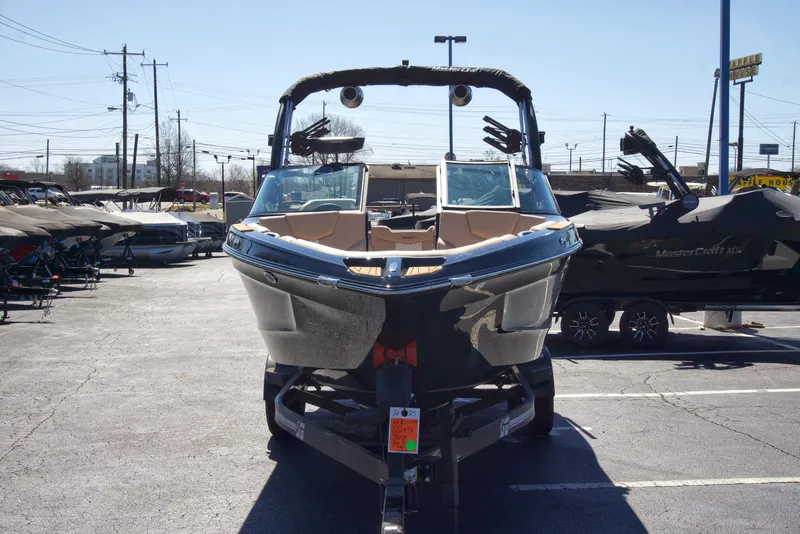 Slide: The Image of 2025 MasterCraft XT23 boat on trailer in parking lot, front view. - 2