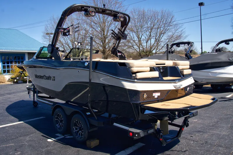 Slide: The Image of 2025 MasterCraft XT23 boat on trailer, parked outdoors, showcasing sleek design and modern features. - 5