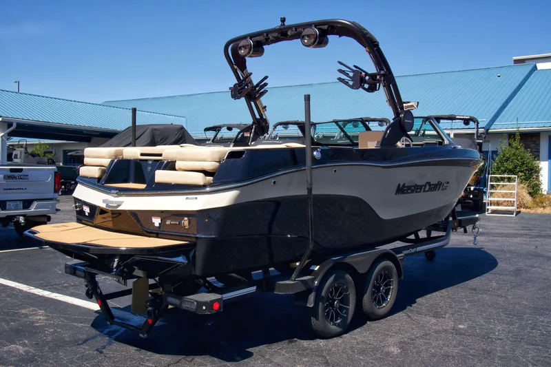 Slide: The Image of 2025 MasterCraft XT23 boat on trailer, parked outdoors, showcasing sleek design and modern features. - 6