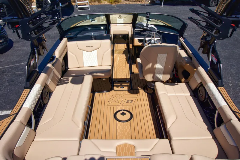 Slide: The Image of 2025 MasterCraft XT23 boat interior with beige seating and sleek design. - 7