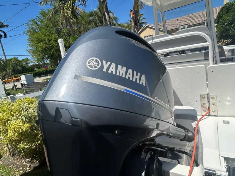 Slide: The Image of Yamaha outboard motor on 2023 Release 210 RX boat, sunny day, palm trees in background. - 10