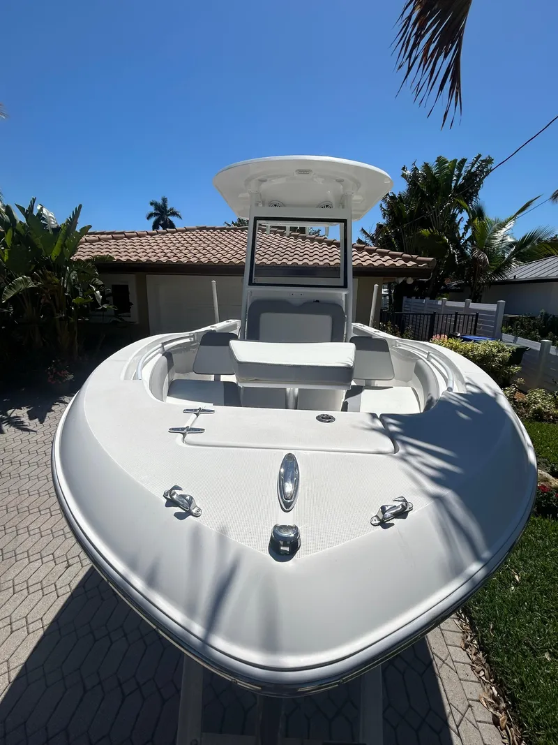 Slide: The Image of 2023 Release 210 RX boat with sleek design, parked outdoors under clear blue sky. - 13