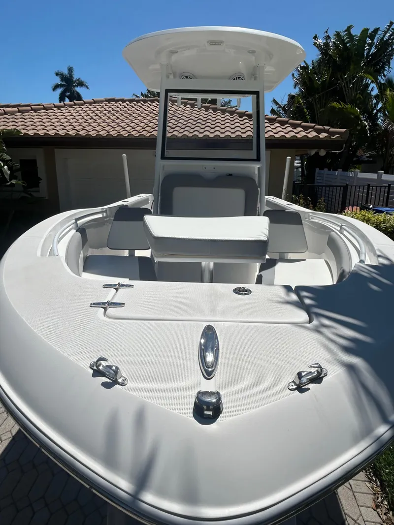 Slide: The Image of 2023 Release 210 RX boat with sleek design, docked near a house, under clear blue sky. - 15