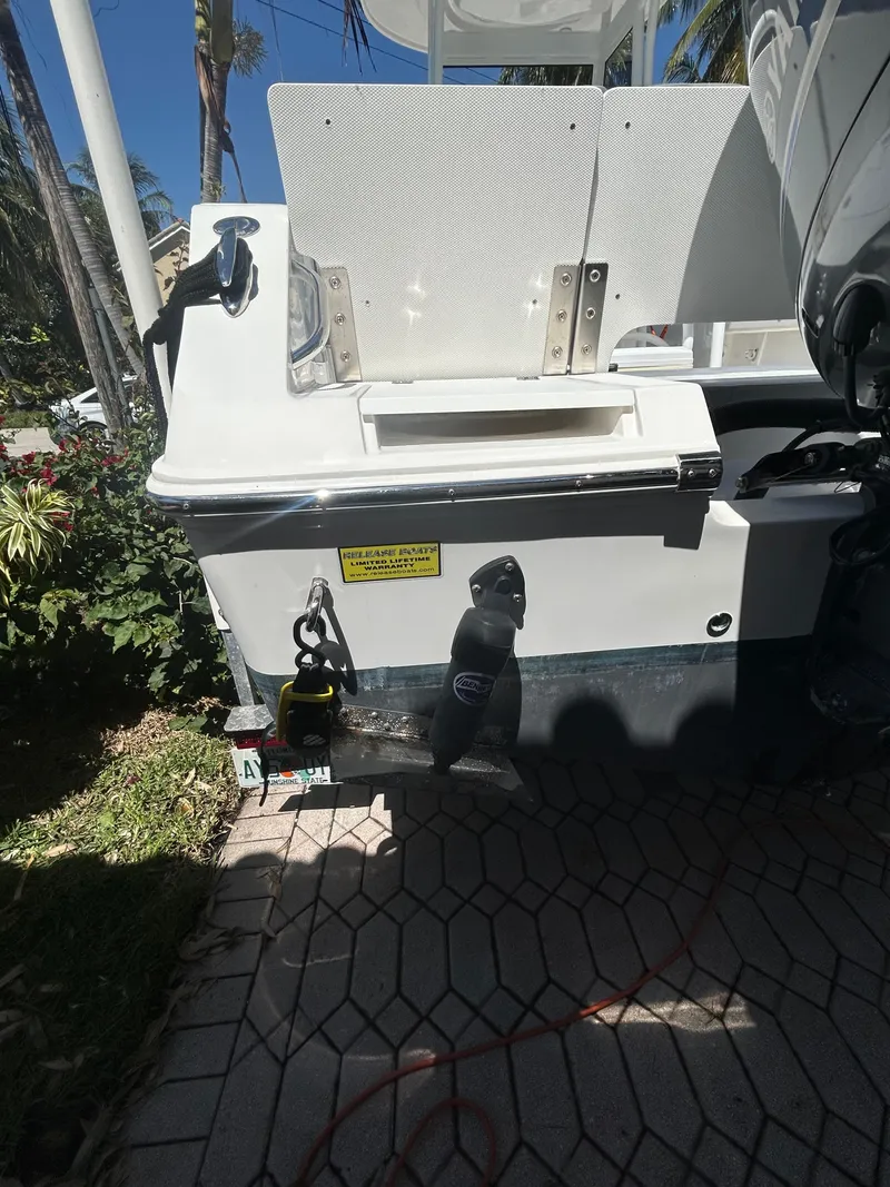 Slide: The Image of 2023 Release 210 RX boat stern with motor, docked on patterned pavement. - 16