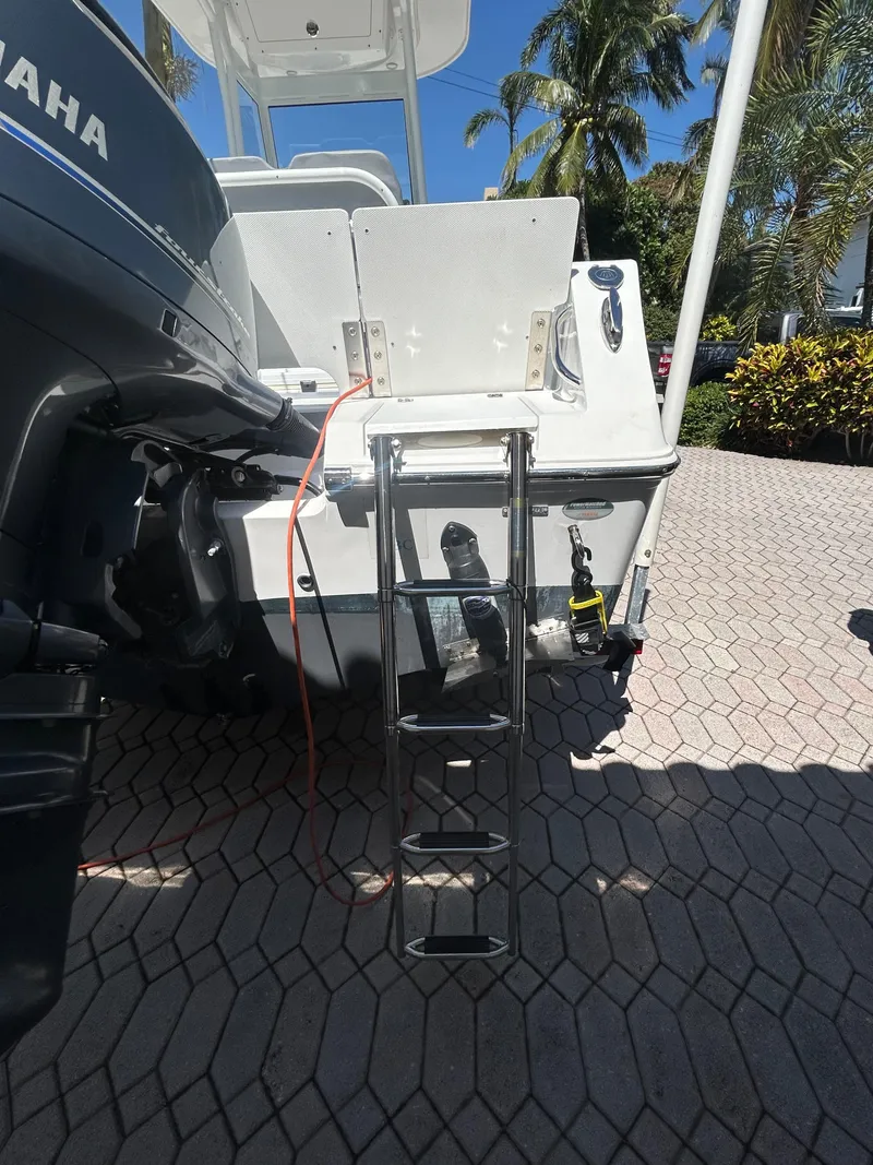 Slide: The Image of 2023 Release 210 RX boat with ladder, Yamaha engine, and tropical background. - 17