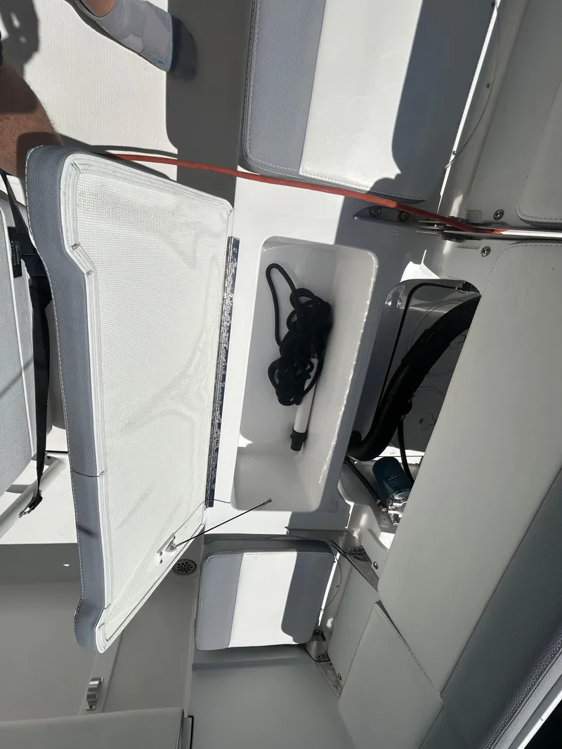 Slide: The Image of Interior view of 2023 Release 210 RX boat, featuring storage compartments and seating. - 18