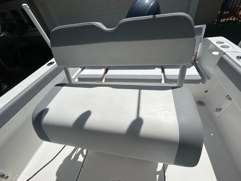 Slide: The Image of 2023 Release 210 RX boat seat, gray and white upholstery, sunlight casting shadows. - 19