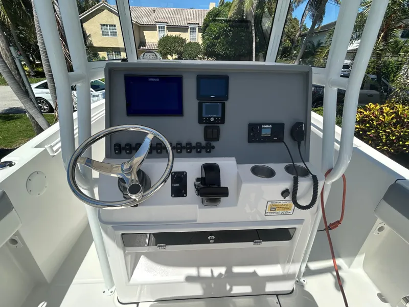Slide: The Image of 2023 Release 210 RX boat console with steering wheel, navigation screens, and controls. - 25