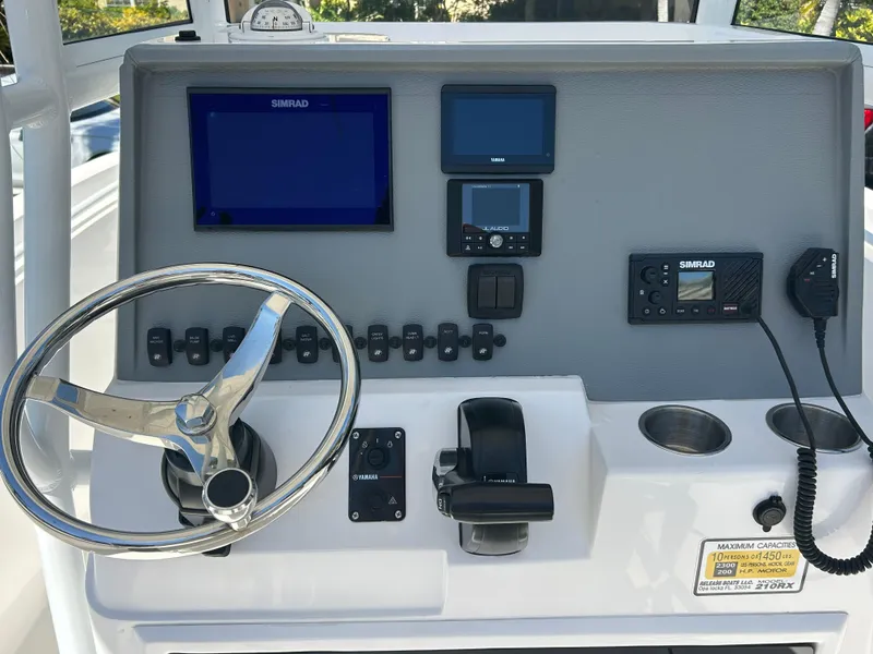 Slide: The Image of 2023 Release 210 RX boat dashboard with steering wheel, navigation screens, and controls. - 26