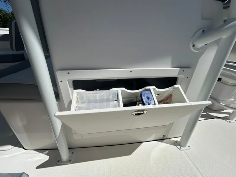 Slide: The Image of Storage compartment on a 2023 Release 210 RX boat, featuring organized tackle boxes. - 34