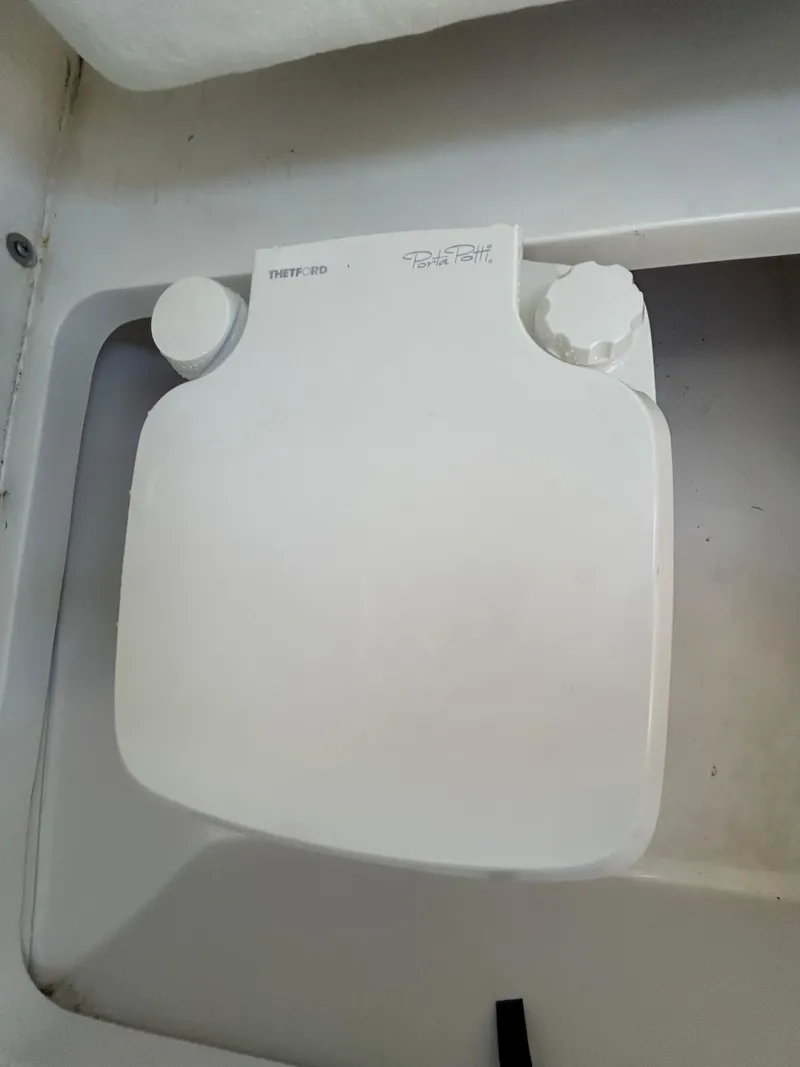 Slide: The Image of White Thetford toilet lid in a 2023 Release 210 RX model. - 35