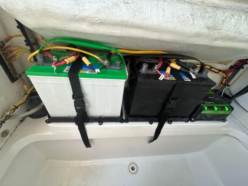 Slide: The Image of Two secured marine batteries in a 2023 Release 210 RX boat compartment. - 36