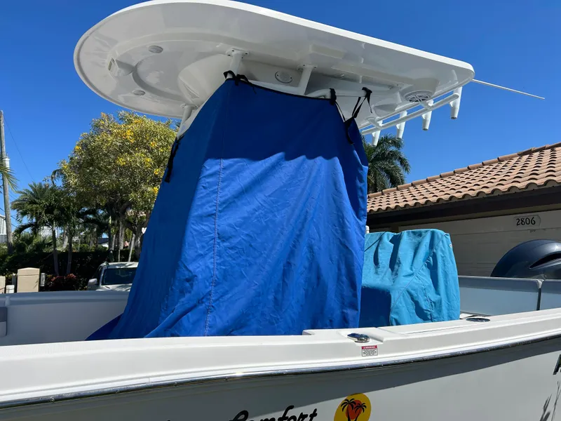 Slide: The Image of 2023 Release 210 RX boat with blue cover, parked outdoors under clear sky. - 38
