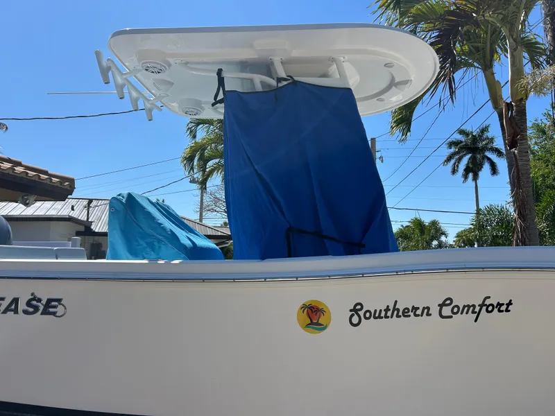 Slide: The Image of 2023 Release 210 RX boat named "Southern Comfort" with blue cover and palm trees in background. - 39
