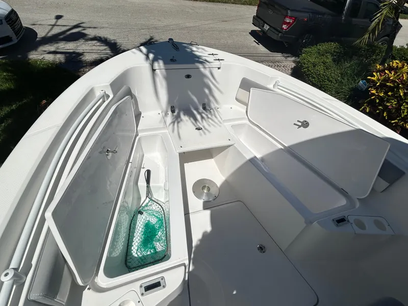 Slide: The Image of 2023 Release 210 RX boat interior with open storage compartments and fishing net. - 41