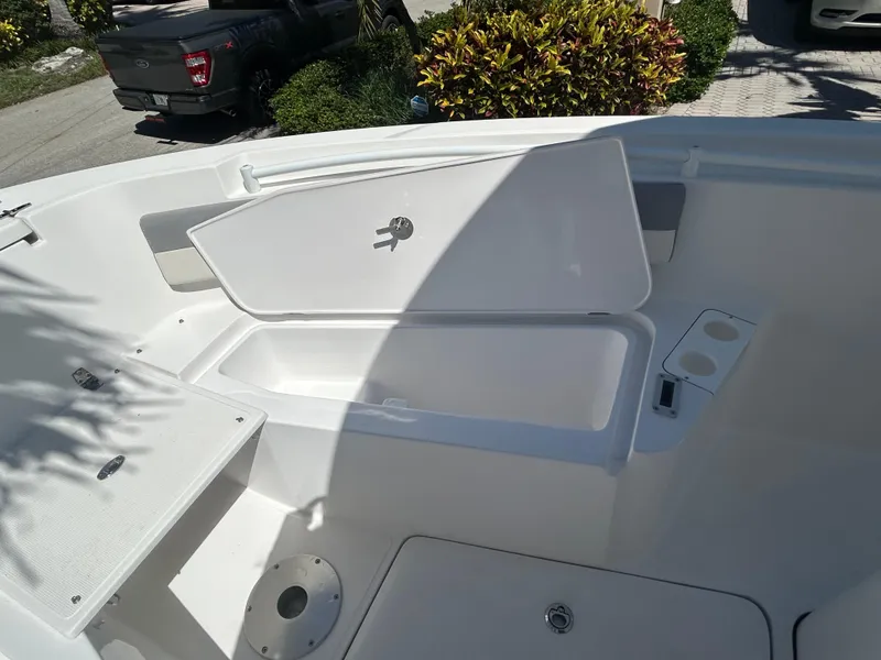 Slide: The Image of 2023 Release 210 RX boat interior with open storage compartment and cup holder. - 43