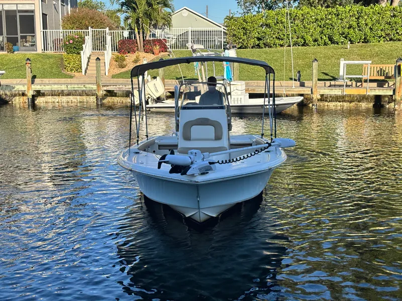 Slide: The Image of 2017 Key West 230 Bay Reef boat docked in a serene canal setting. - 1