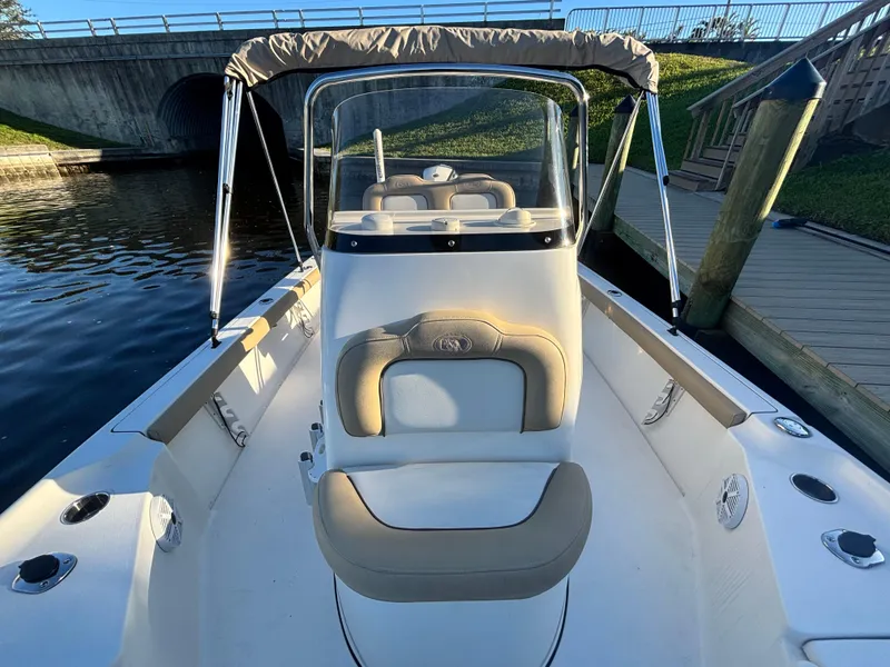 Slide: The Image of 2017 Key West 230 Bay Reef boat with seating and canopy, docked by a bridge. - 10