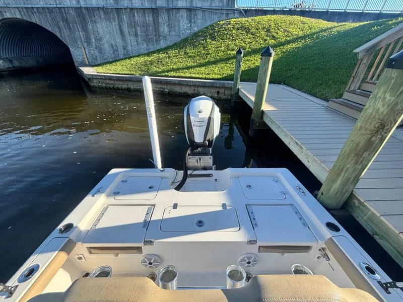 Slide: The Image of 2017 Key West 230 Bay Reef boat docked near a wooden pier, with outboard motor visible. - 17