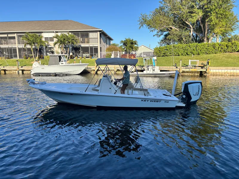 Slide: The Image of 2017 Key West 230 Bay Reef boat on calm water near residential docks. - 2