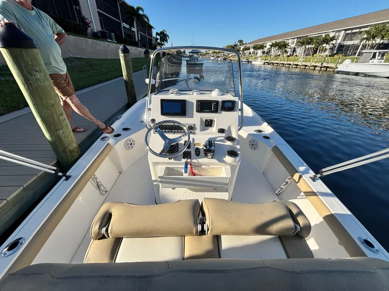 Slide: The Image of 2017 Key West 230 Bay Reef boat docked in a canal, featuring a spacious cockpit. - 3