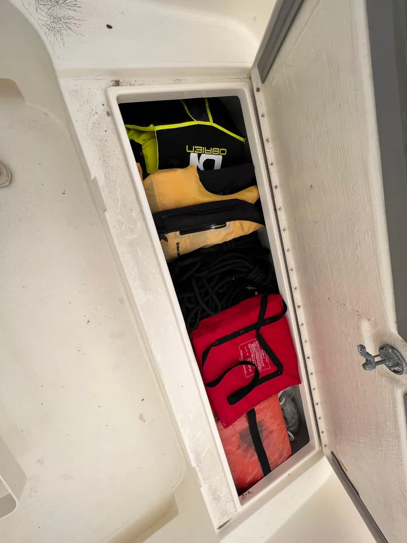 Slide: The Image of Storage compartment on a 1998 World Cat 270TE boat with life jackets and gear. - 11