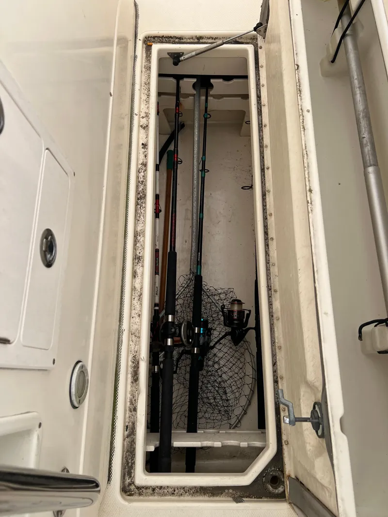 Slide: The Image of 1998 World Cat 270TE storage compartment with fishing rods and net. - 15
