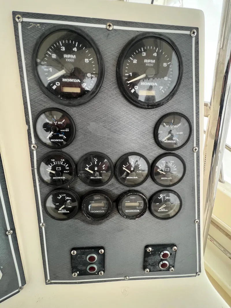 Slide: The Image of Dashboard of a 1998 World Cat 270TE boat with various gauges and controls. - 23