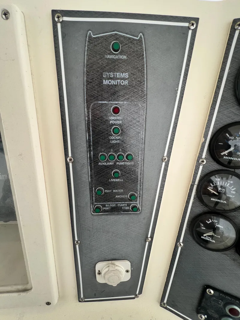 Slide: The Image of Control panel of a 1998 World Cat 270TE boat, featuring system monitor indicators. - 24